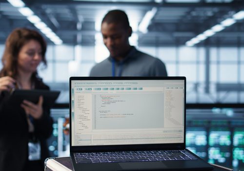 Programming language on notebook used by server room IT experts, close up choix des outils et architecture informatique